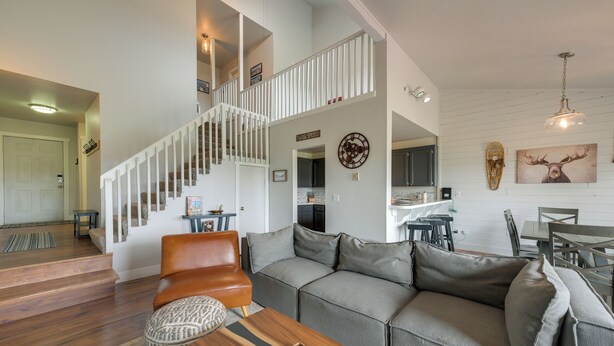 A spacious living area with a wooden staircase, a gray sofa, and a dining table. - Lake + Mountain Views! Pagosa Springs Getaway (Pagosa Springs)