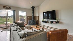 A living room with a sofa, ottoman, coffee table, fireplace, TV, and a sign that reads 'LAKE'. - Lake + Mountain Views! Pagosa Springs Getaway (Pagosa Springs)
