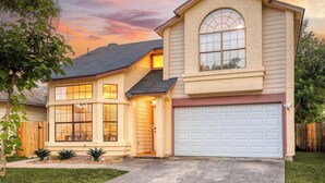 A two-story house with a garage, large windows, and a tree in the front yard. - Private Pool! Family Getaway, 5 Mi to Seaworld (San Antonio)