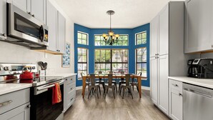 A modern kitchen with a dining table, built-in appliances, and large windows. - Private Pool! Family Getaway, 5 Mi to Seaworld (San Antonio)