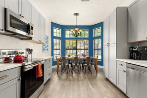 A modern kitchen with a dining table, built-in appliances, and large windows. - Private Pool! Family Getaway, 5 Mi to Seaworld (San Antonio)
