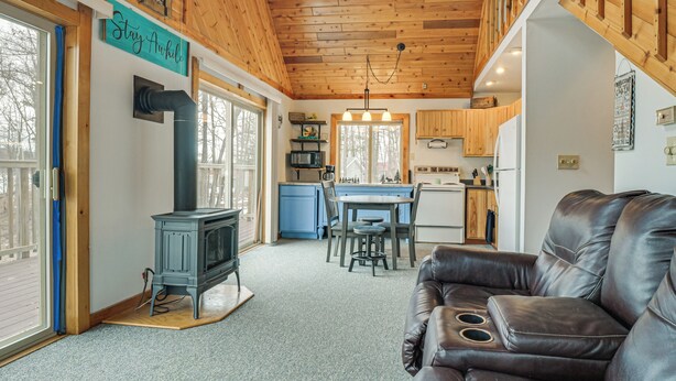 Ein gemütliches Blockhaus-Interieur mit Kamin, Essbereich und einer Ledersofa.
