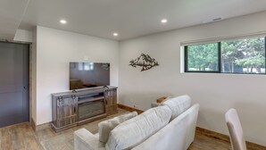 Ein Wohnzimmer mit Fernseher, einer Couch und einem Kamin.