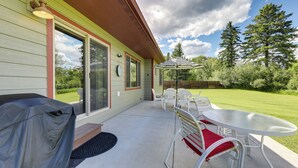 A covered patio with a table and chairs, a barbecue grill, and a view of the surrounding greenery. - 4 Mi to Dtwn! Columbia Falls Home w/ Spacious Yard (Columbia Falls)