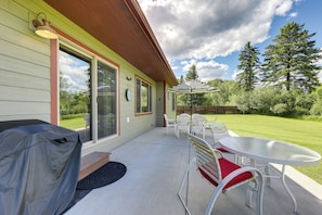 A covered patio with a table and chairs, a barbecue grill, and a view of the surrounding greenery. - 4 Mi to Dtwn! Columbia Falls Home w/ Spacious Yard (Columbia Falls)