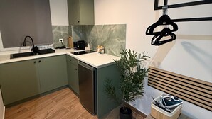 A modern kitchen with a built-in dishwasher, a marble backsplash, and a wooden floor. - Athenian Stay 305 Apartment Monastiraki (Athens)