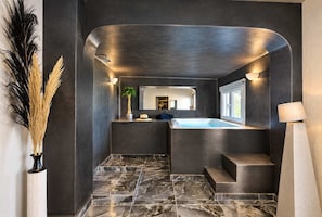 A modern bathroom with a marble floor, a built-in jacuzzi, and a large mirror. - Grande Studio with Jacuzzi Nea Premium Residences (Imerovigli)