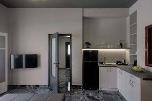 A modern kitchen with a refrigerator, sink, and cabinets. - Grande Studio with Jacuzzi Nea Premium Residences (Imerovigli)