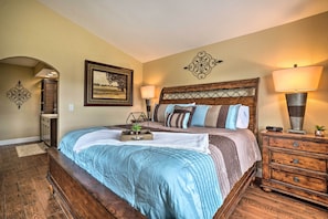 A bedroom with a wooden bed, a nightstand, a lamp, and a framed picture on the wall. - Dual-unit Group Retreat, 1 Block to Branson Strip! (Branson)