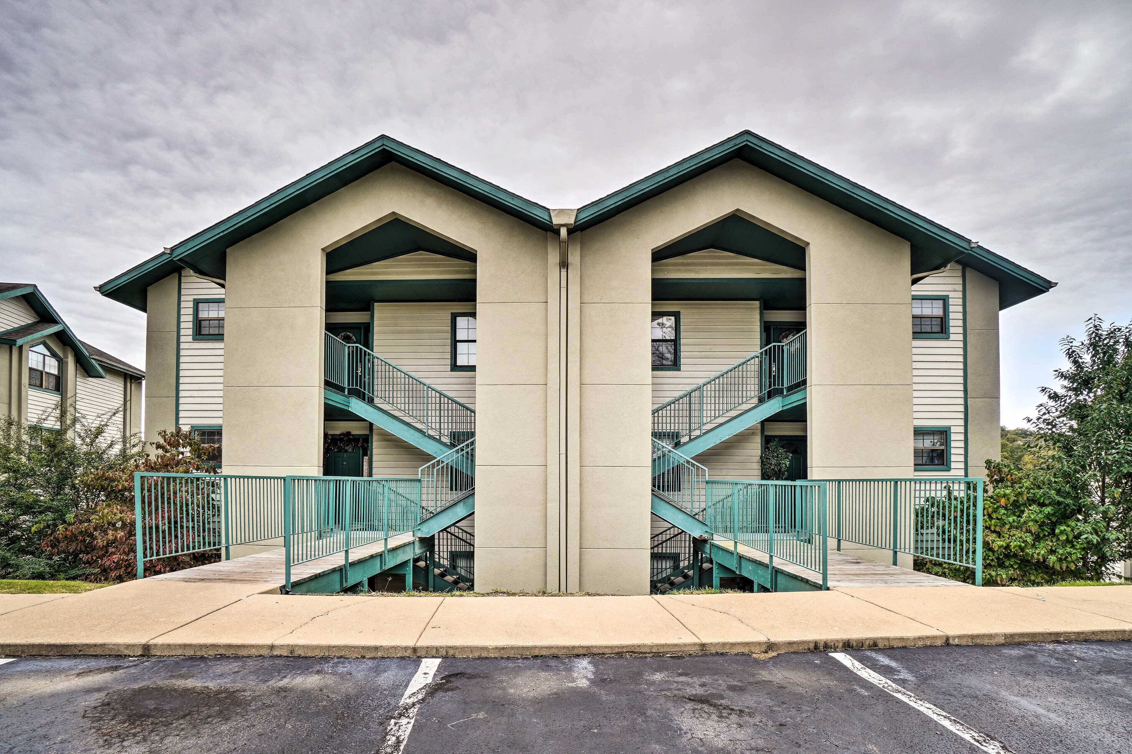 Un bâtiment symétrique doté de deux escaliers, d’un toit plat et d’un rez-de-chaussée en béton.