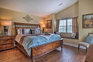 A bedroom with a large wooden bed, two bedside tables, a window with curtains, and a bench by the window. - Dual-unit Group Retreat, 1 Block to Branson Strip! (Branson)
