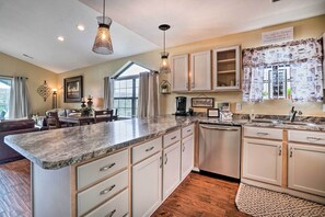 A modern kitchen with granite countertops, white cabinets, and a built-in dishwasher. - Dual-unit Group Retreat, 1 Block to Branson Strip! (Branson)