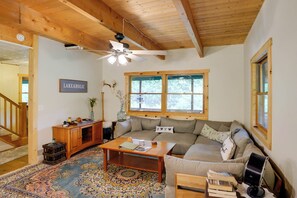 A cozy living room with a wooden ceiling, a sofa, a coffee table, and a sign that reads 'LAKEAHOLIC.' - Walk to the Water! Lake George Family Getaway (Town of Putnam)