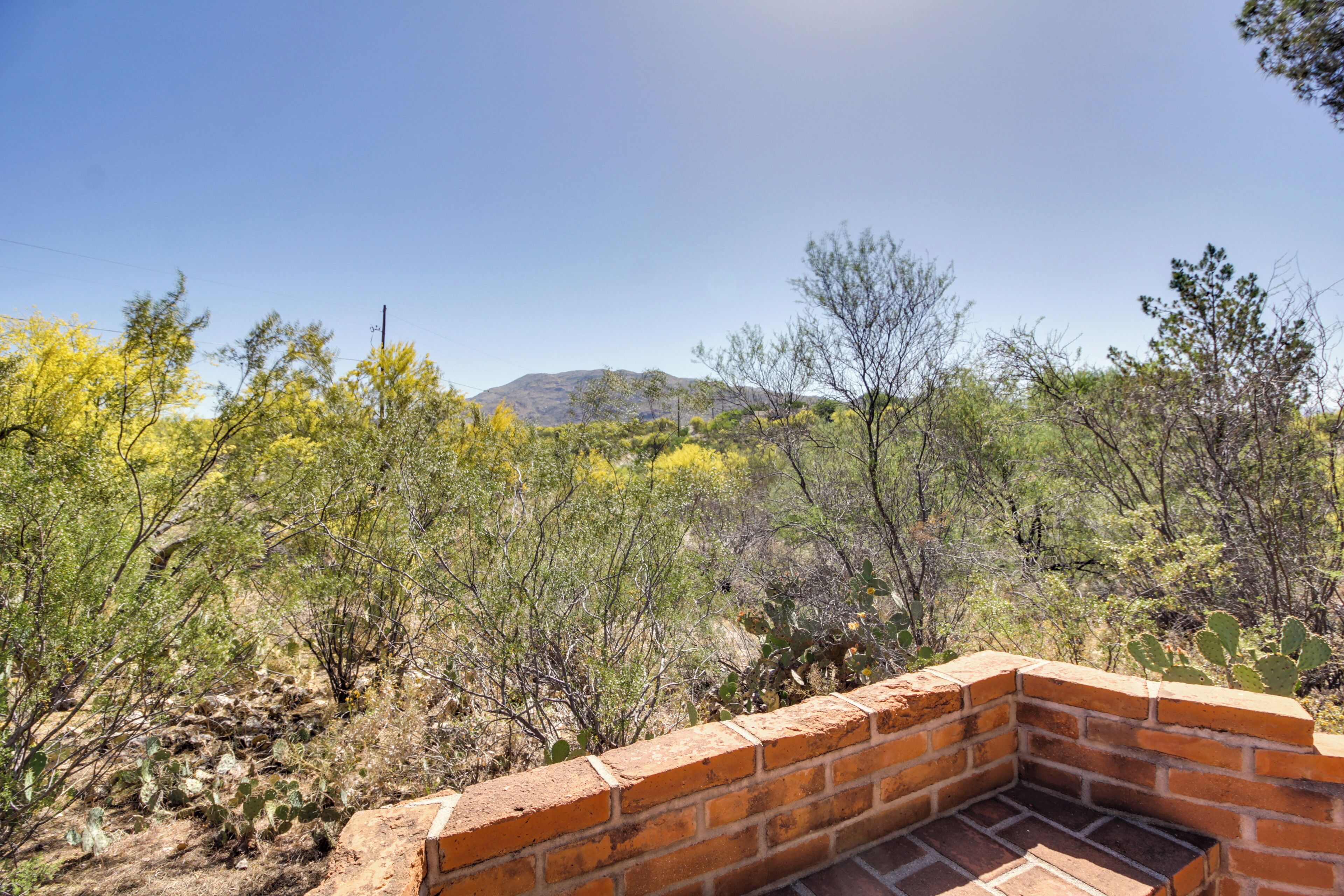 A brick patio with a view of a desert landscape.