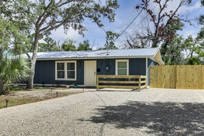 A single-story building with a gravel driveway, wooden fence, and a small porch with a bench. - Steinhatchee River Hideaway, 1 Mi to the Water! (Steinhatchee)