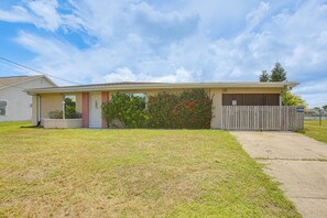 A single-story house with a front porch, a garage, and a small front yard. - 4 Mi to Beach Park! Canal-front Port Charlotte Gem (Port Charlotte)