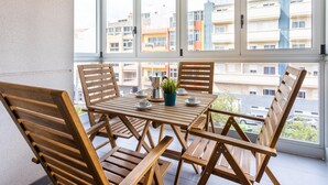 A balcony with a wooden table and chairs, a coffee maker, and a potted plant. - CHL Apartamento Confort Güímar, Tenerife (Güimar)