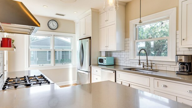 A modern kitchen with a large island, stainless steel appliances, and a window providing natural light. - Bring Your Pets! Phoenix Family Getaway w/ Patio (Phoenix)
