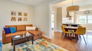 A living room with a sofa, coffee table, and artwork on the wall. - Bring Your Pets! Phoenix Family Getaway w/ Patio (Phoenix)