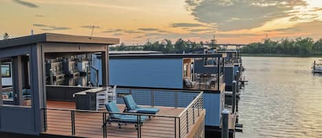 A waterfront property with multiple levels, outdoor seating areas, and a view of the water.