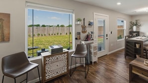 Un amplio salón con un ventanal grande, una mesa de comedor y una zona de cocina.
