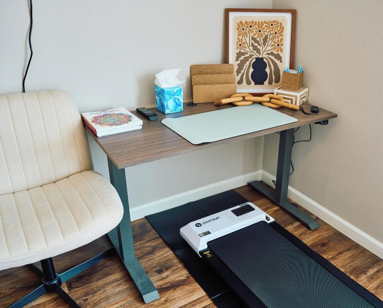A room with a desk, chair, exercise equipment, and a framed picture.