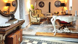 Una habitación con piso a cuadros, un espejo, una mesa y una silla.