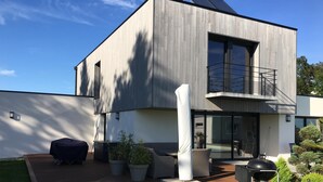 A modern two-story house with a patio, outdoor furniture, and a barbecue grill. - Quiet Villa with Pool - Saint Nolff (Saint-Nolff)