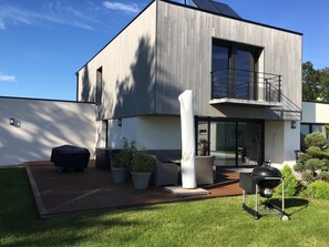 A modern two-story house with a patio, outdoor furniture, and a barbecue grill. - Quiet Villa with Pool - Saint Nolff (Saint-Nolff)