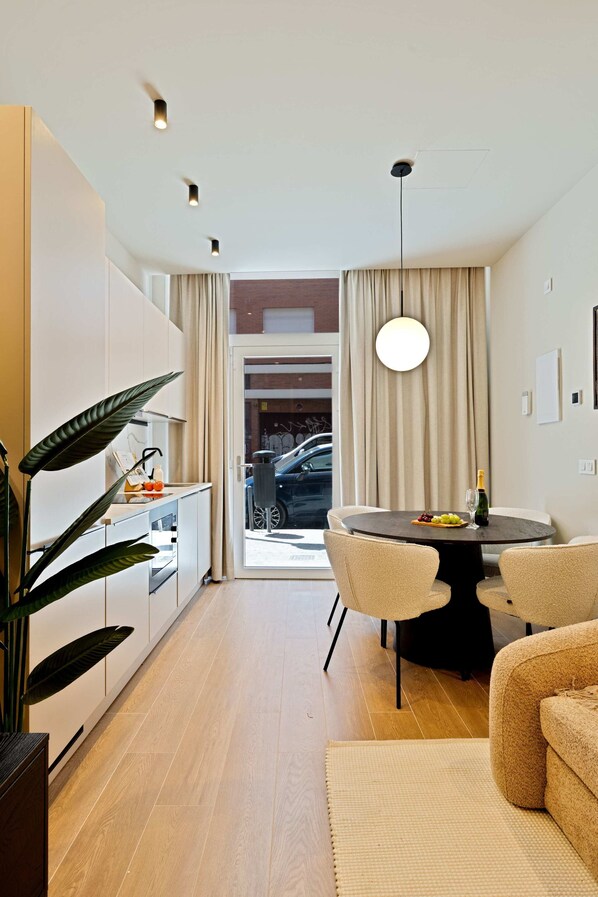 A modern kitchen with a dining area, a large plant, and a view of the street. - Saristays Valencia Luxe Style (València)