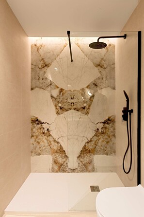A modern bathroom with a marble wall, a shower area, and a toilet. - Saristays Valencia Luxe Style (València)