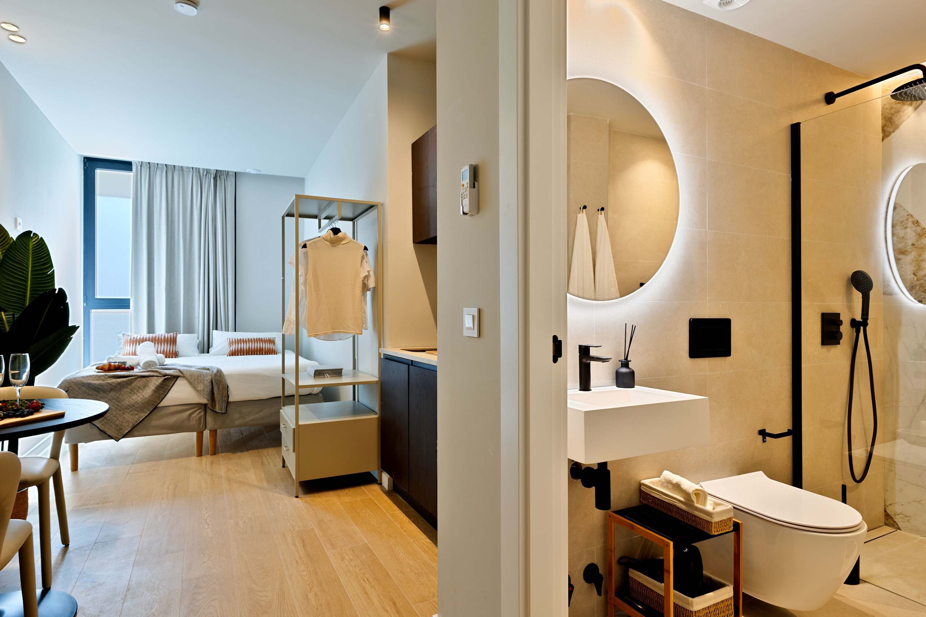 A modern hotel room with a bed, bedside table, and a view of the city.