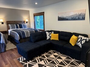 Une chambre à coucher avec un lit, deux tables de chevet, un canapé et un tapis.