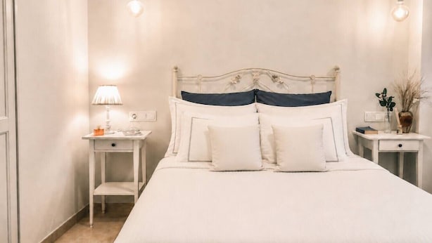 Un dormitorio ordenado con cama, mesitas de noche y una lámpara.