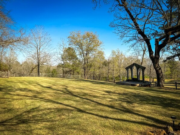 A park with a gazebo, open grassy areas, and trees.