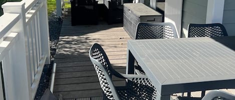 A covered patio with outdoor furniture, a white fence, and a view of neighboring houses.