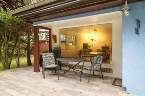 An outdoor patio with a table and chairs, a wooden door, and a view of the interior. - Holiday Home for 6 Guests in Graal-Müritz (Baltic Sea Spa) (Graal-Müritz)