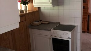 A compact kitchen with white cabinets, a built-in oven, and a small countertop. - Holiday Home for 6 Guests in Graal-Müritz (Baltic Sea Spa) (Graal-Müritz)