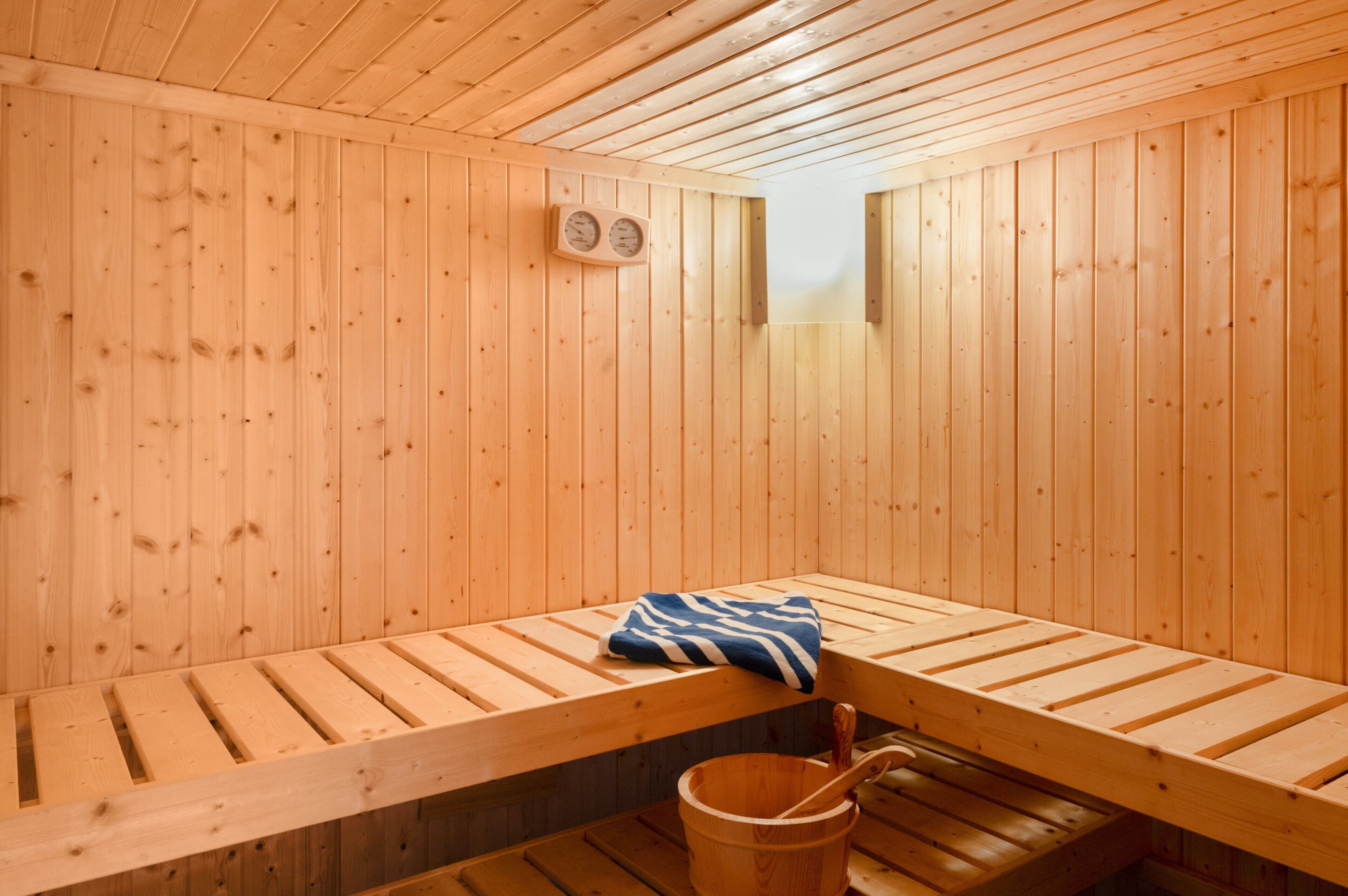 Una sala de sauna con bancos de madera y una toalla.