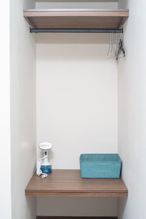 A small, enclosed space with a shelf, a blue storage box, and a white device. - Loft junto al metro | Directo al Estadio BBVA (Monterrey)