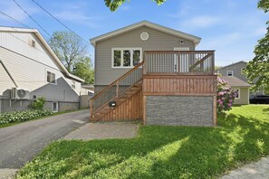 A two-story house with a wooden staircase, a stone accent wall, and a mailbox. - Modern Suite Minutes from Halifax Waterfront (Halifax)