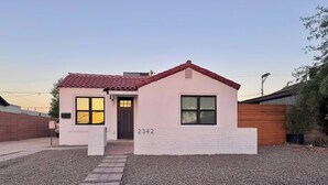 A single-story building with a red-tiled roof, a brick entrance, and a gravel driveway. - Coronado Historic Casita · King Bed · Private Yard · Phoenix (Phoenix)