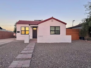 A single-story building with a red-tiled roof, a brick entrance, and a gravel driveway. - Coronado Historic Casita · King Bed · Private Yard · Phoenix (Phoenix)