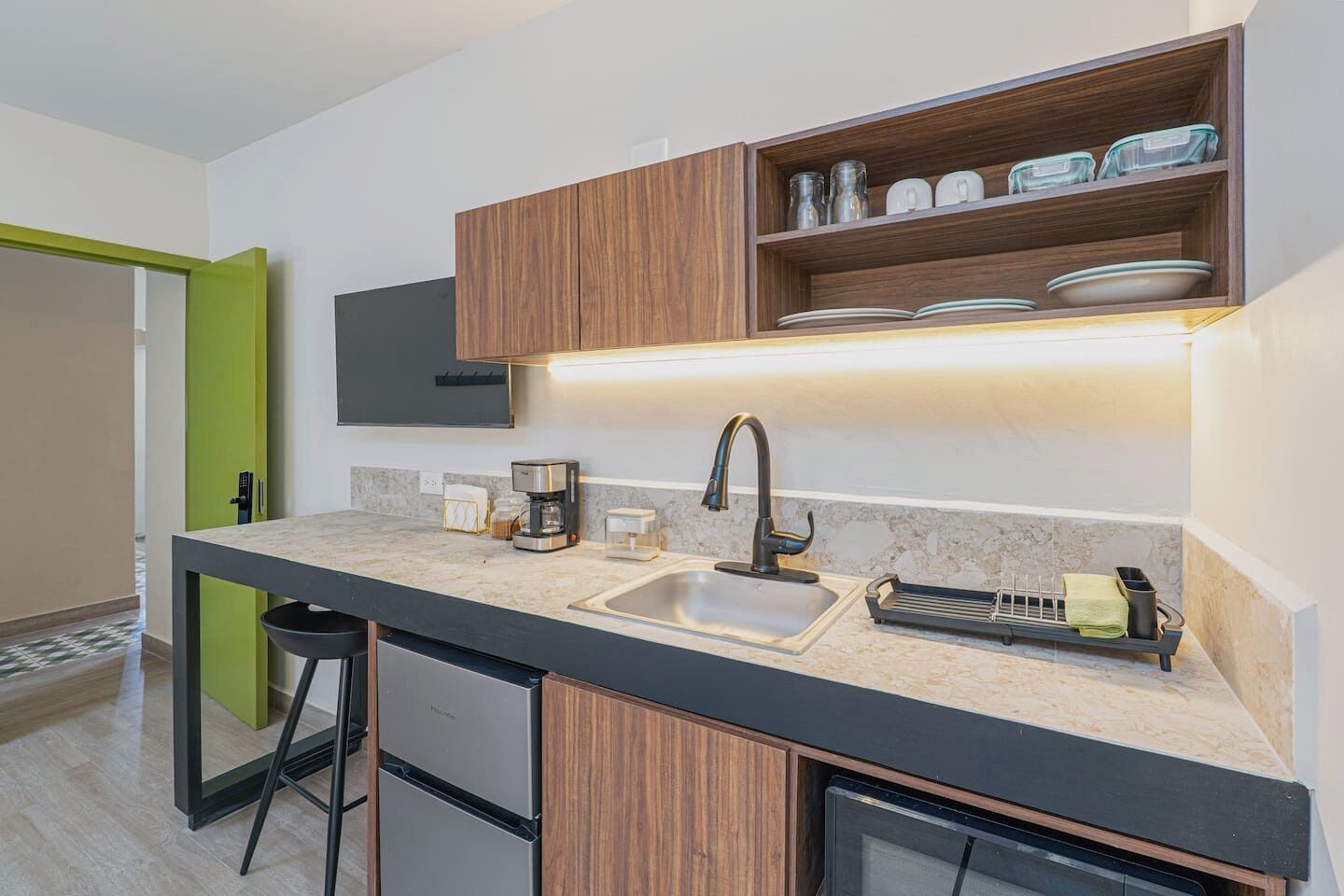 A modern kitchen with a built-in sink, a coffee maker, and a dish rack.