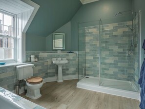 Une salle de bain équipée de toilettes, d’un lavabo et d’une douche à parois en verre.