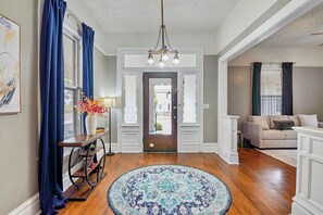 A spacious living room with a large window, a sofa, and a coffee table. - Newly renovated Magic on 17th! Min from Protective, UAB, BJCC. Sleeps 10 (Birmingham)