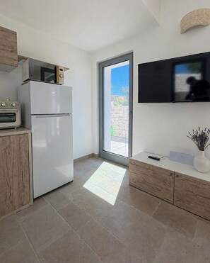 A modern kitchen with a built-in oven, microwave, and a refrigerator. - Trullo with infinity pool amid olive groves (Alberobello)