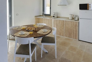 A dining area with a round table, chairs, and breakfast items. - Trullo with infinity pool amid olive groves (Alberobello)