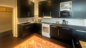 Eine moderne Küche mit dunklen Schränken, einem Gasherd, einer Mikrowelle und einem Backofen.