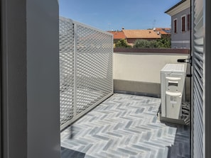 A small balcony with a metal fence, a water dispenser, and a tiled floor. - Casa Nuvola (Senigallia)